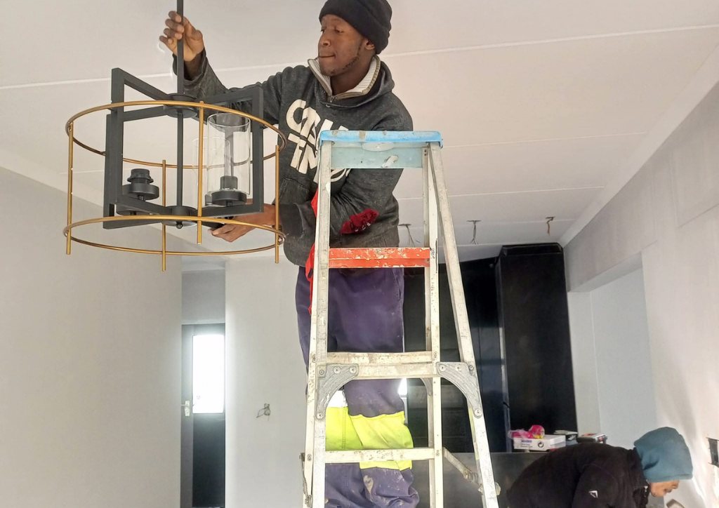 Commercial electrician installing energy-efficient LED lighting in an office and commercial building in Cape Town.